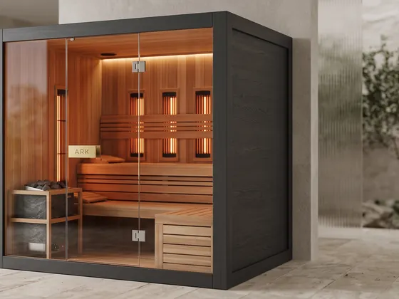 ARK Hybrid Sauna for two in black, with a glass front, an electric stove with stones and infrared panels on the back wall